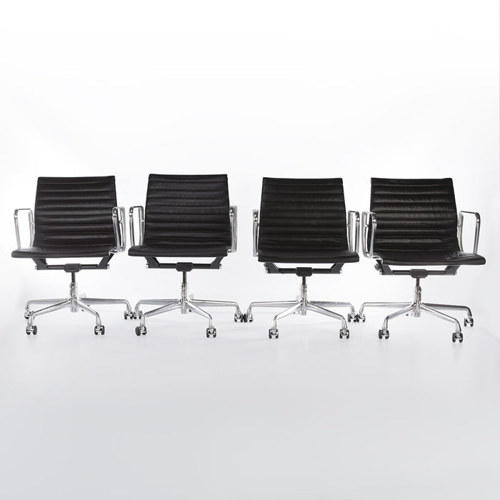 Front view of set of 4 black Eames EA335 Office Chairs in a line