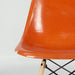 Artistic front view of orange Eames DSW dining side chair