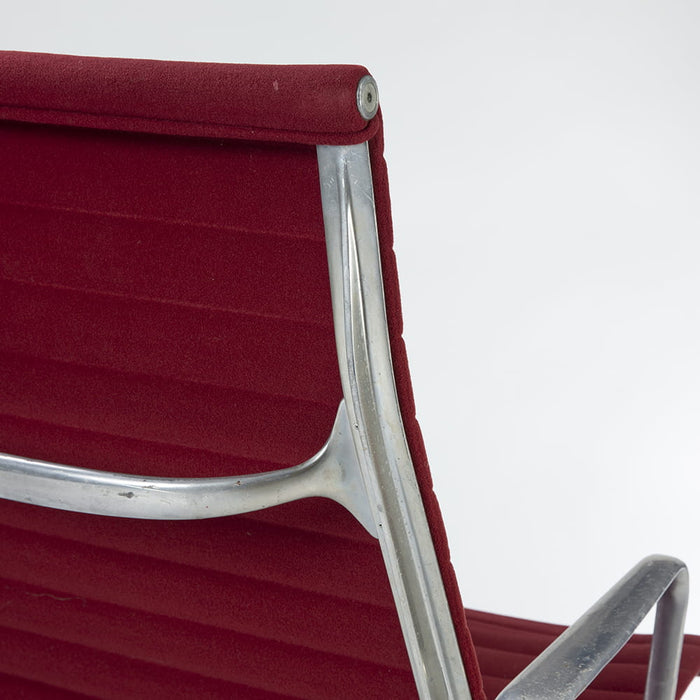 Close up rear angled view of red Eames EA316 aluminium lounge chair