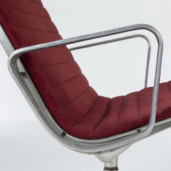 Close up side view of red Eames EA316 aluminium lounge chair