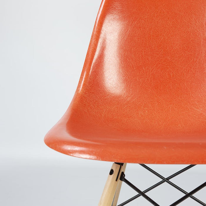 Artistic front view of orange Eames DSW dining side chair