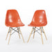 Front angled view of pair of orange Eames DSW dining side chairs