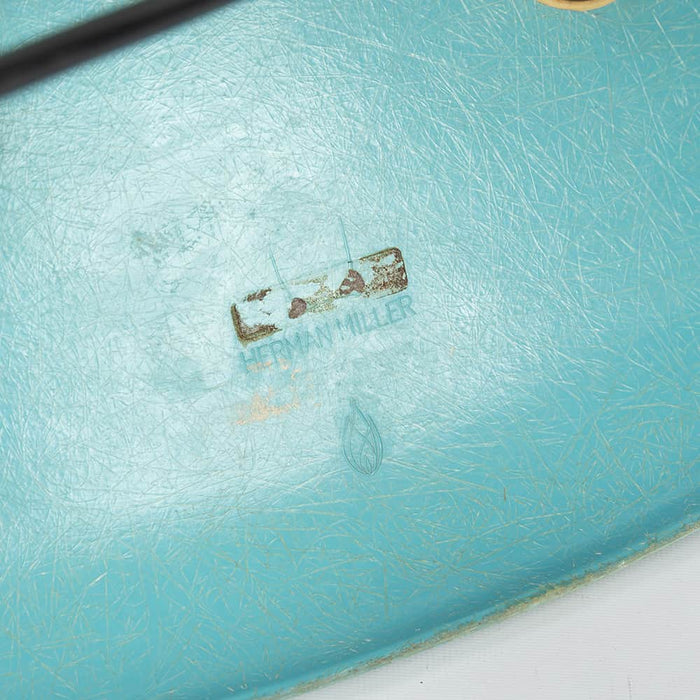 View of logo on turquoise Eames DSW dining chair