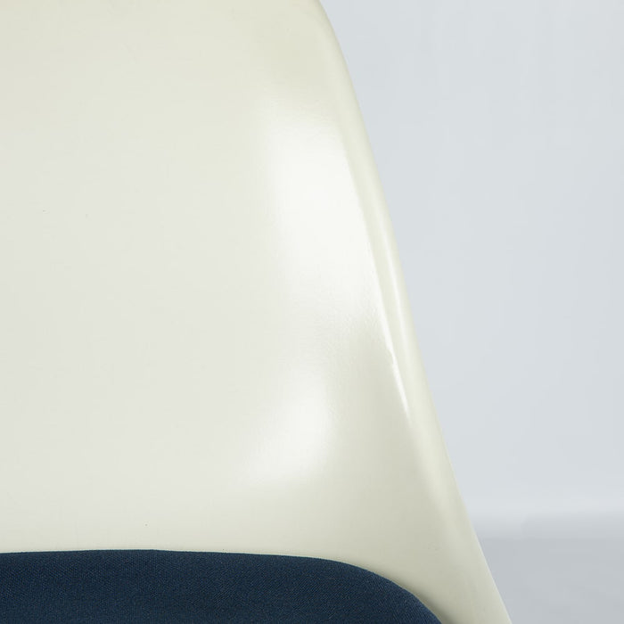 Close up front angled view of white and blue Eames DFSR dining side chair