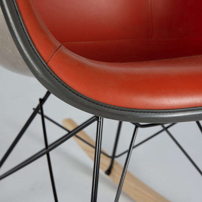 Close up front angled view of red vinyl Eames RAR rocking arm chair