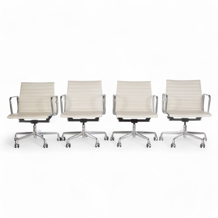 View of set of 4 white Eames EA335 office chairs in a line