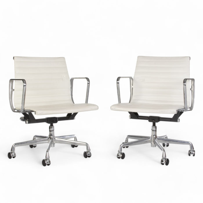 Front angled view of pair of white Eames EA335 office chairs