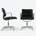 View of pair of black Eames EA408S chairs, one from front, one from right side