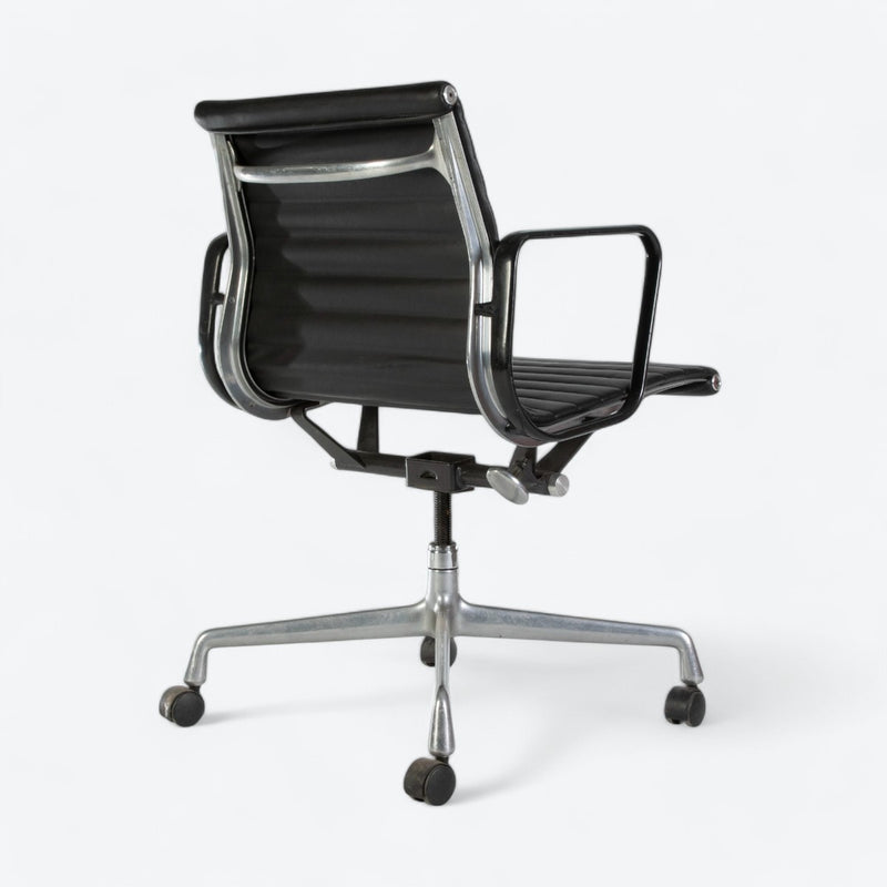 Rear angled view of black Eames EA318 office chair