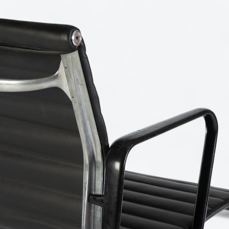 Close up rear angled view of black Eames EA318 office chair