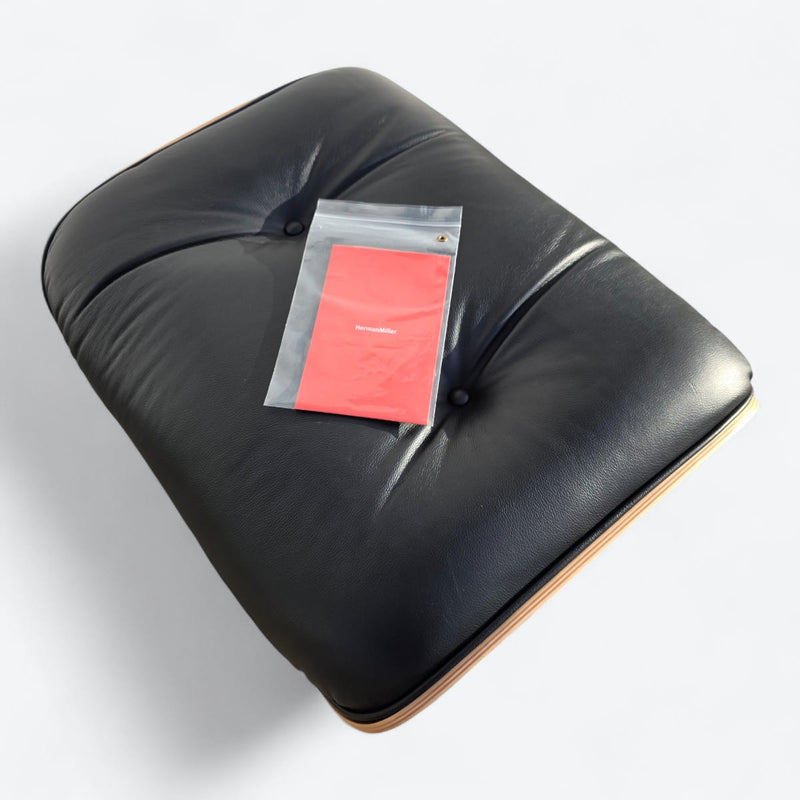 Top view of black and walnut Eames Lounge Chair Ottoman with Paperwork