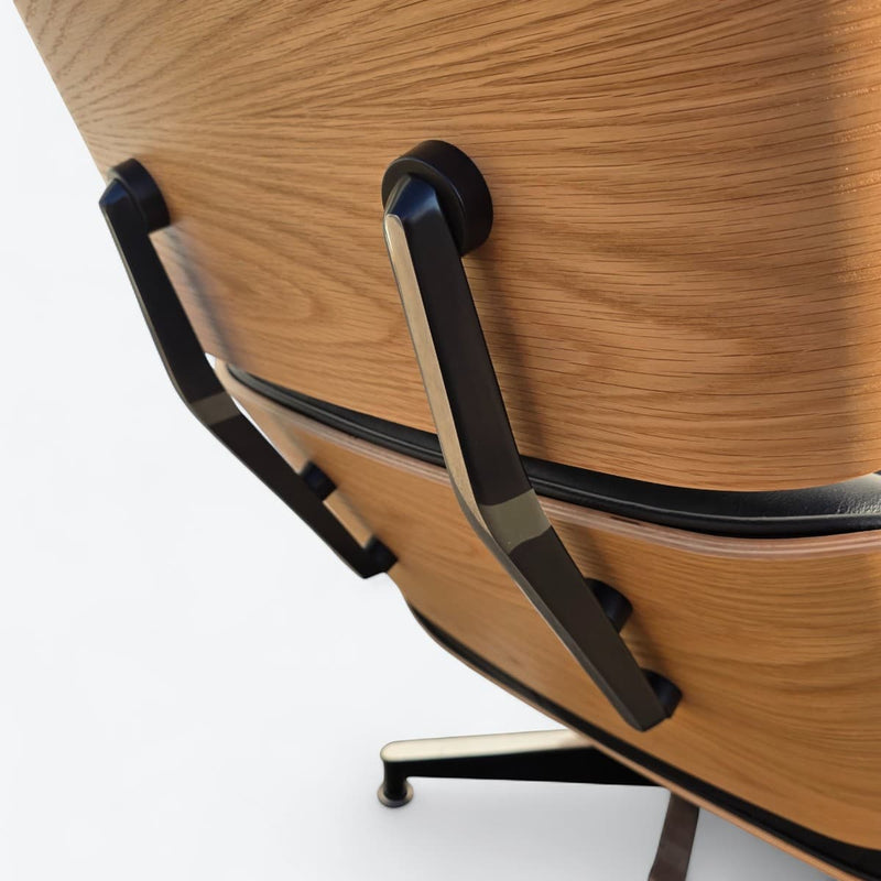 Close up angled rear view of black and oak tall Eames Lounge Chair