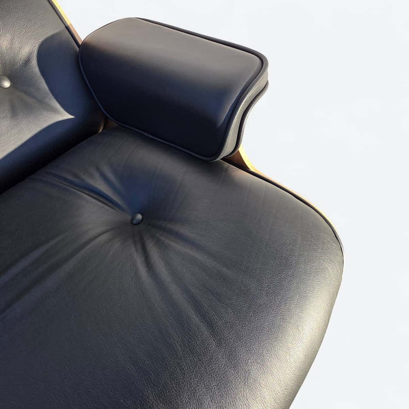 View of arm on black and oak tall Eames Lounge Chair