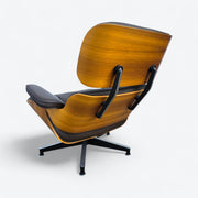 Left side rear angled view of brown walnut Eames Lounge Chair