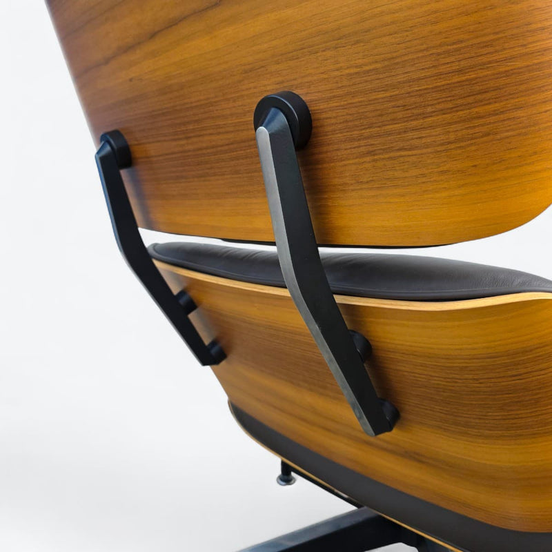 Close angled view of back of brown walnut Eames Lounge Chair