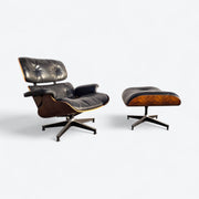 Angled right side view of black and rosewood Eames lounge chair and ottoman