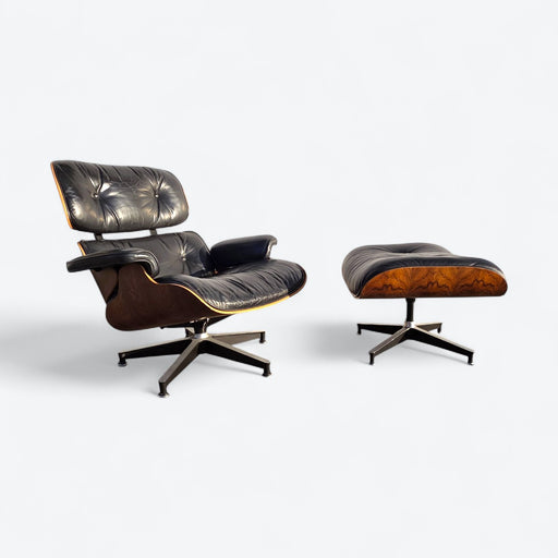 Angled right side view of black and rosewood Eames lounge chair and ottoman