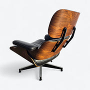 Rear left angled view of black and rosewood Eames lounge chair