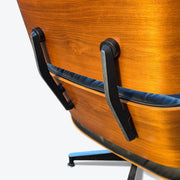 Close up rear angled view of black and walnut Eames Lounge Chair