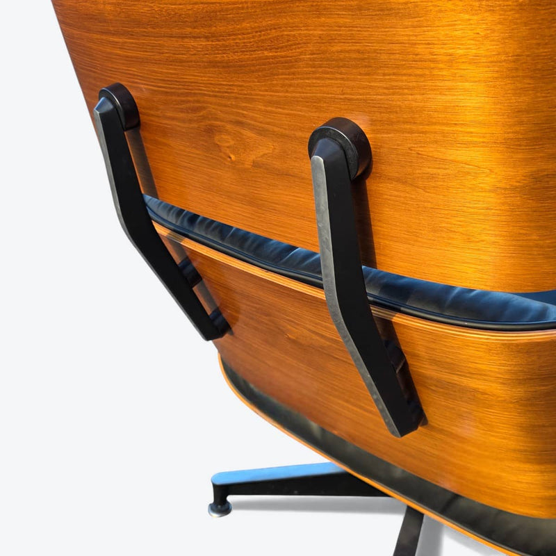 Close up rear angled view of black and walnut Eames Lounge Chair