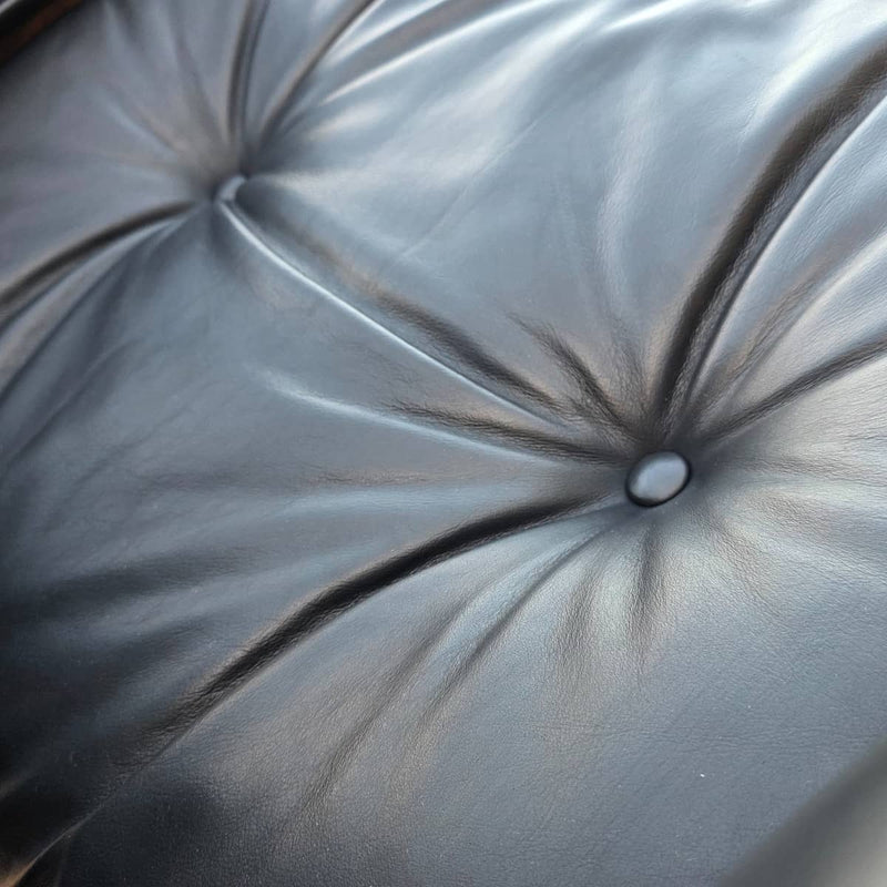 Close up view of leather on black and walnut Eames Lounge Chair and Ottoman