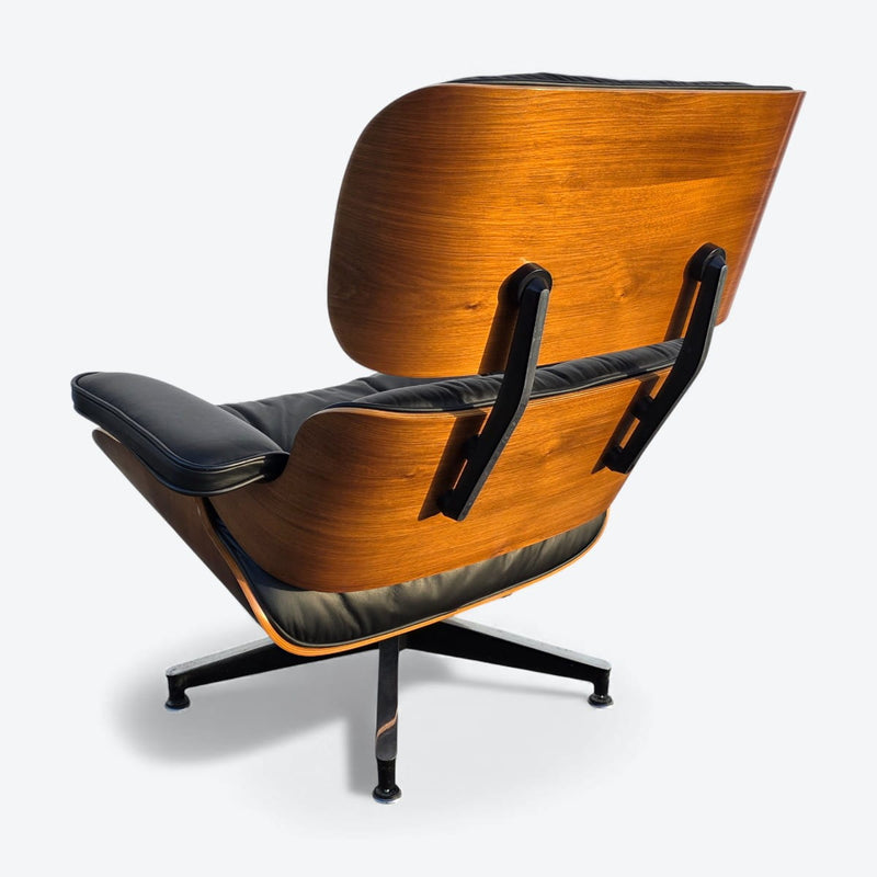 Left rear view of black and walnut Eames Lounge Chair