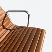 Close up view of leather on tan Eames EA335 office chair