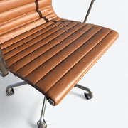 Top down close up view of leather on tan Eames EA335 office chair
