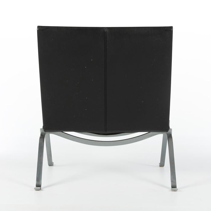 Rear view of black leather Kjaerholm PK22 lounge chair