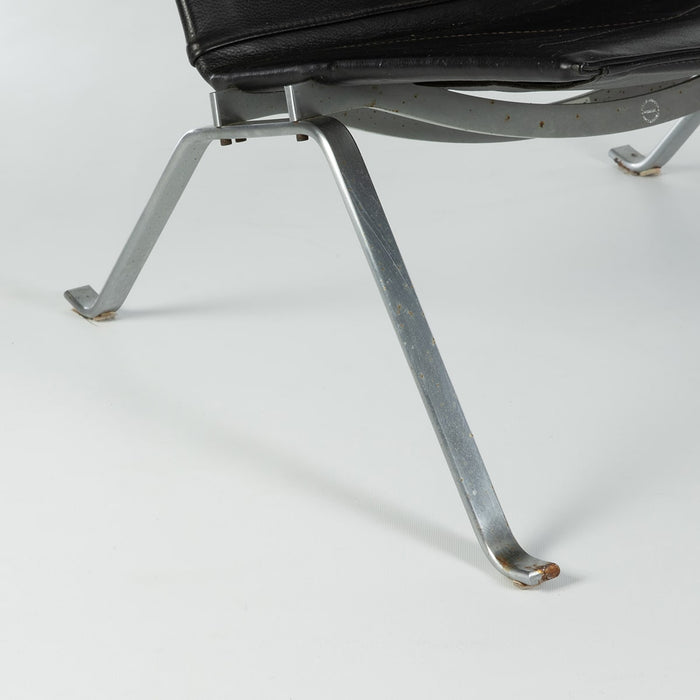 Close up view of frame on black leather Kjaerholm PK22 lounge chair