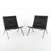 Front angled view of pair of black leather Kjaerholm PK22 lounge chairs