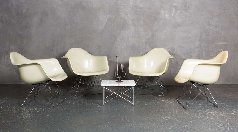 A set of original LAR lounge low fiberglass shell chairs sit around the low rod LTR coffee table that Charles & Ray Eames designed with Japanese influence